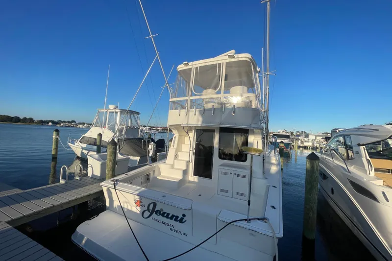 Slide: The Image of 2006 Silverton 42 Convertible yacht docked at marina under clear blue sky. - 2