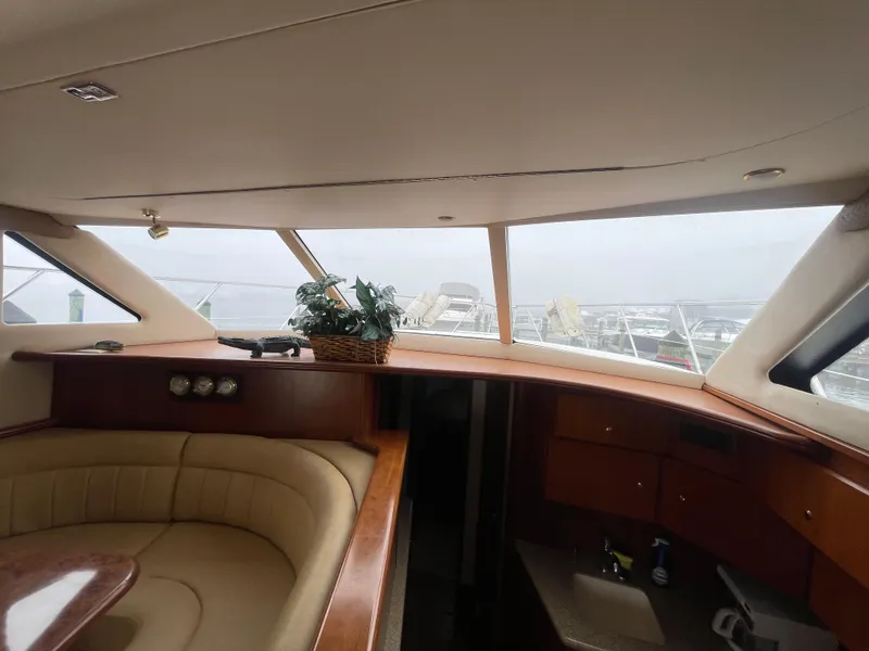 Slide: The Image of Interior of 2006 Silverton 42 Convertible yacht with plush seating and wooden accents. - 23