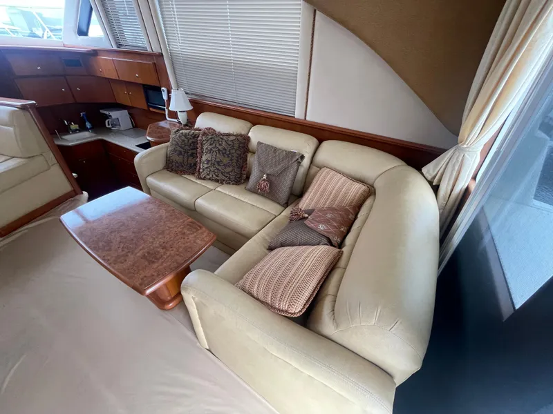 Slide: The Image of Luxurious interior of 2006 Silverton 42 Convertible yacht with beige sofa and wooden accents. - 26