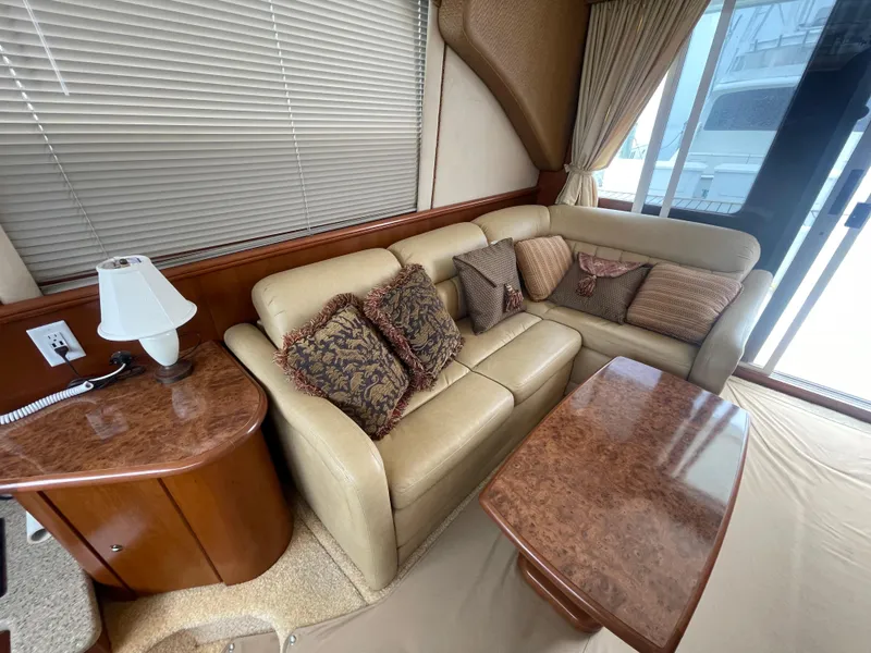 Slide: The Image of Interior of 2006 Silverton 42 Convertible yacht with beige leather seating and decorative pillows. - 27