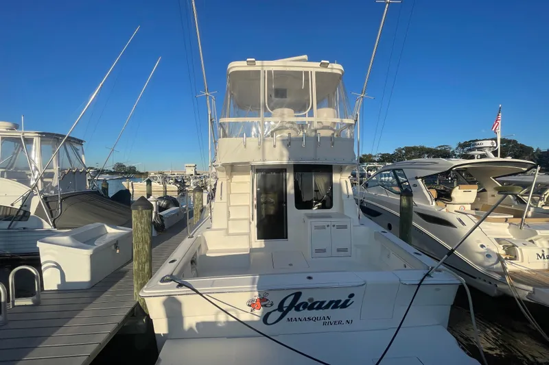 Slide: The Image of 2006 Silverton 42 Convertible yacht docked at marina under clear blue sky. - 3