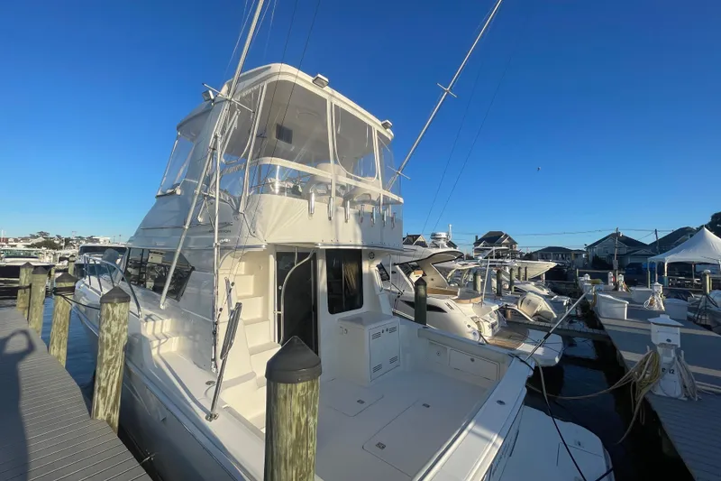 Slide: The Image of 2006 Silverton 42 Convertible yacht docked at marina under clear blue sky. - 4