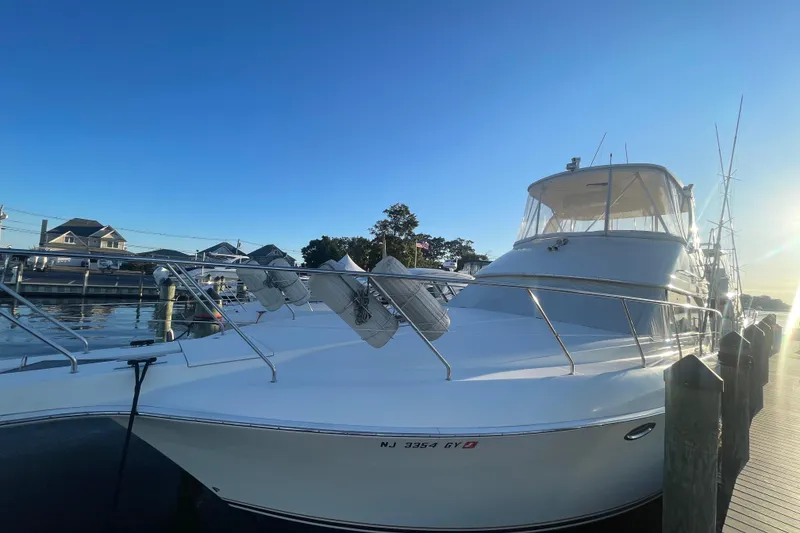 Slide: The Image of 2006 Silverton 42 Convertible yacht docked at marina under clear blue sky. - 5