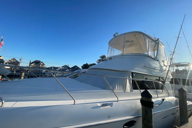Slide: The Image of 2006 Silverton 42 Convertible yacht docked under clear blue sky. - 6