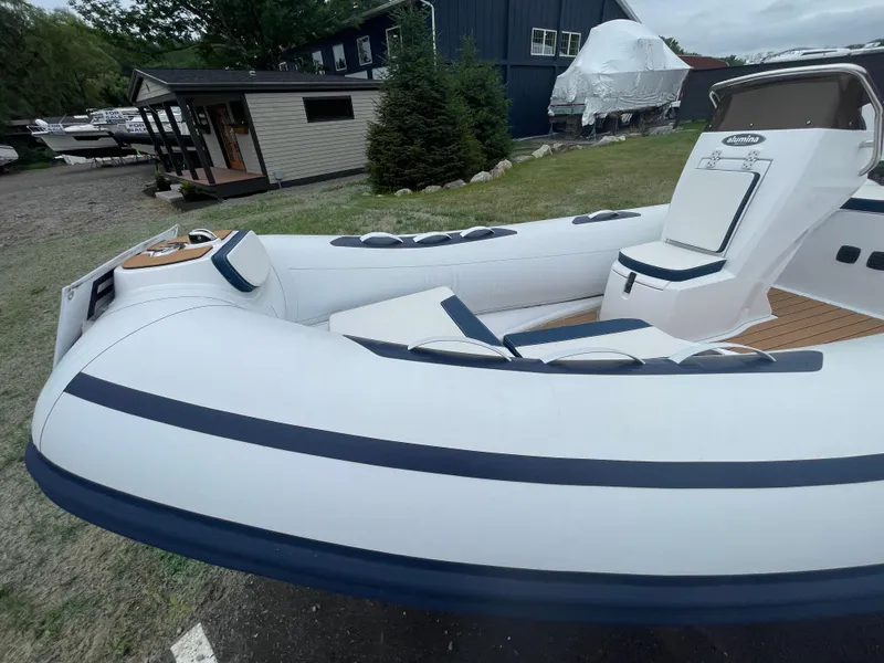 Slide: The Image of 2025 AB Inflatables Alumina 15 ALX boat with sleek design, docked outdoors. - 12