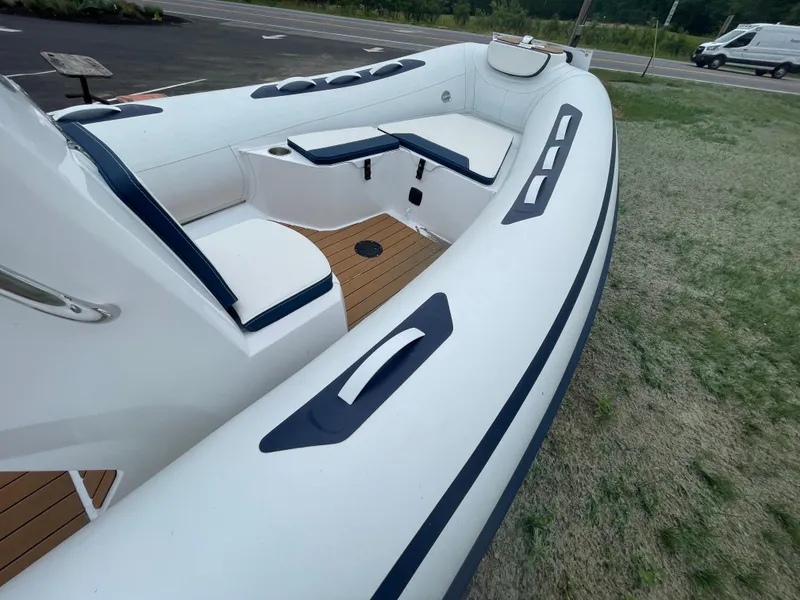 Slide: The Image of 2025 AB Inflatables Alumina 15 ALX boat, white with blue accents, docked on grass. - 9