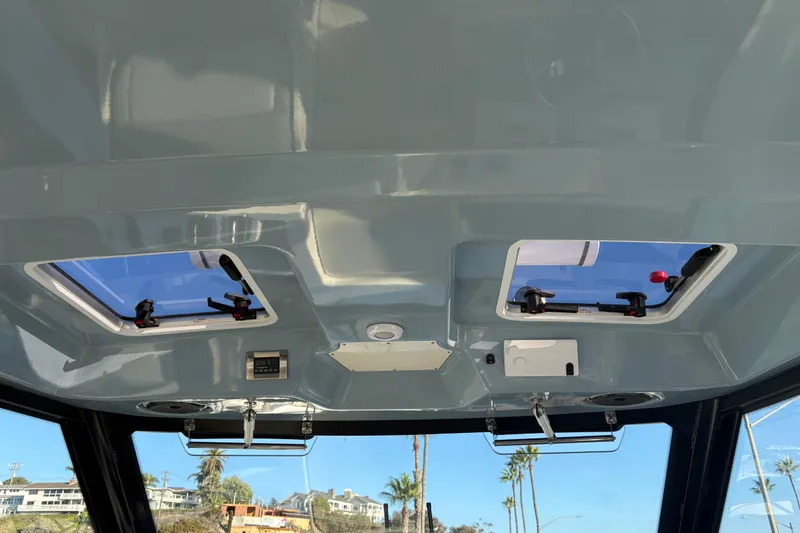 Slide: The Image of Interior view of 2026 Boston Whaler 325 Conquest boat ceiling with hatches and controls. - 18