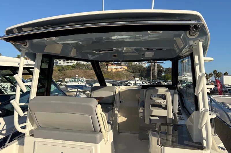 Slide: The Image of 2026 Boston Whaler 325 Conquest boat interior with seating and helm, docked in marina. - 19