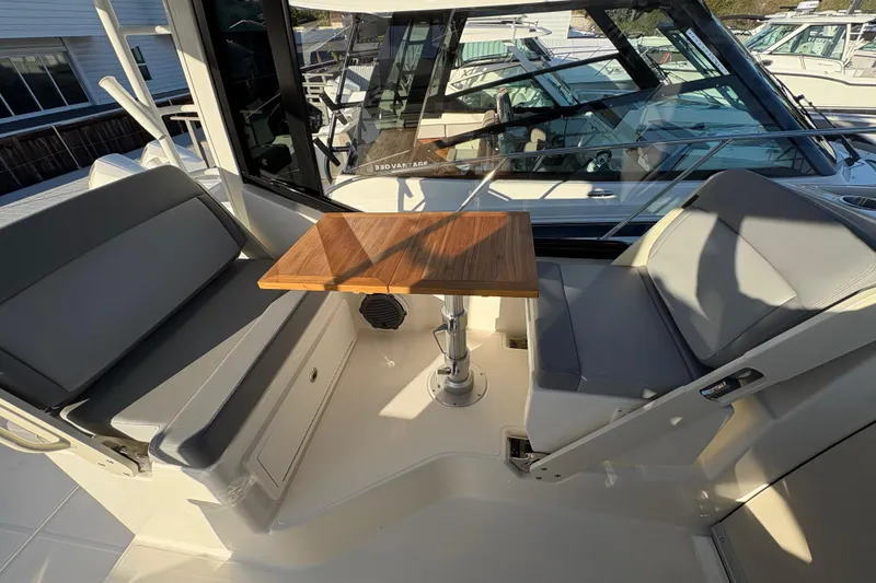 Slide: The Image of 2026 Boston Whaler 325 Conquest interior with seating and wooden table. - 7