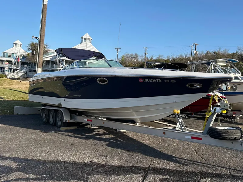 The Image of 2005 Cobalt 343 boat on trailer, parked outdoors under clear blue sky. - 0