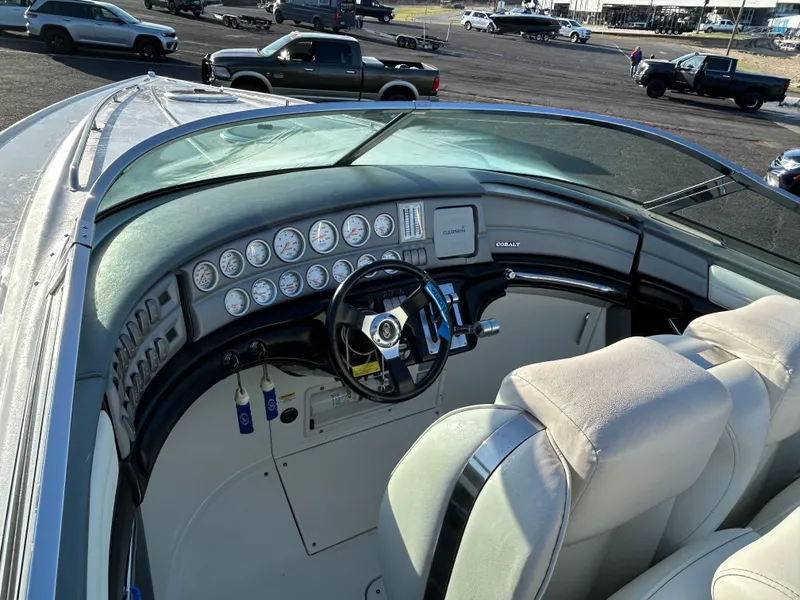 Slide: The Image of 2005 Cobalt 343 boat dashboard with gauges and steering wheel, parked in a lot. - 7