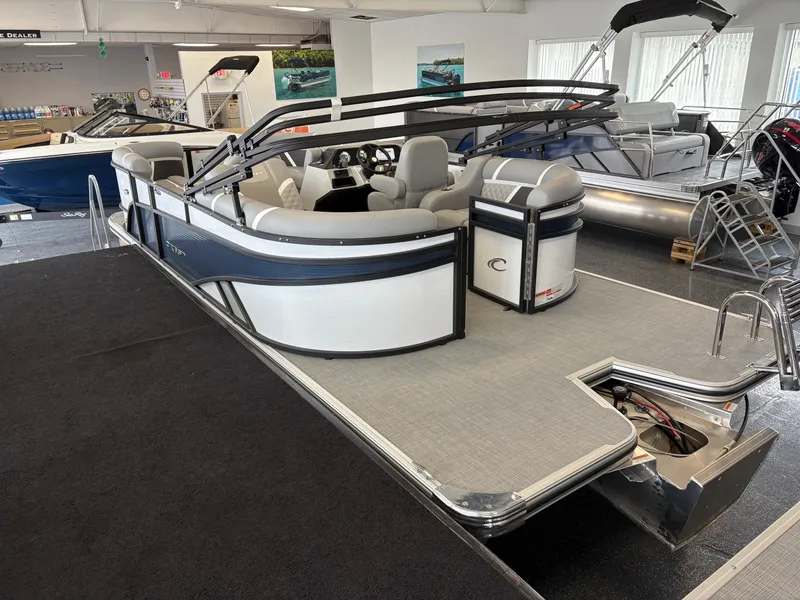 Slide: The Image of 2025 Crest 200 SLC Classic LX pontoon boat in showroom, featuring sleek design and spacious seating. - 3