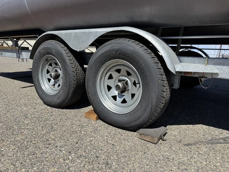 Slide: The Image of Trailer wheels of a 2006 Sun Tracker Party Cruiser 32, secured with wheel chocks. - 15
