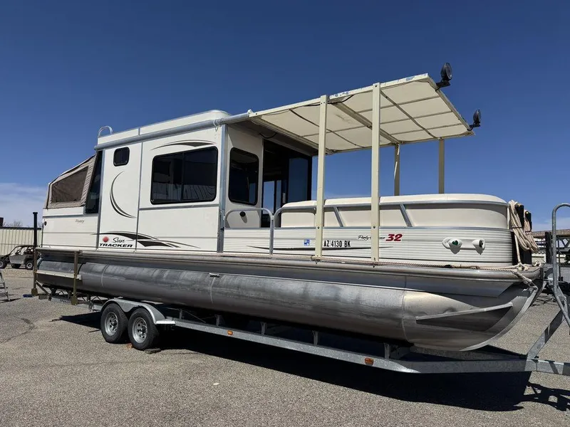 Slide: The Image of 2006 Sun Tracker Party Cruiser 32 pontoon boat on trailer under clear blue sky. - 2