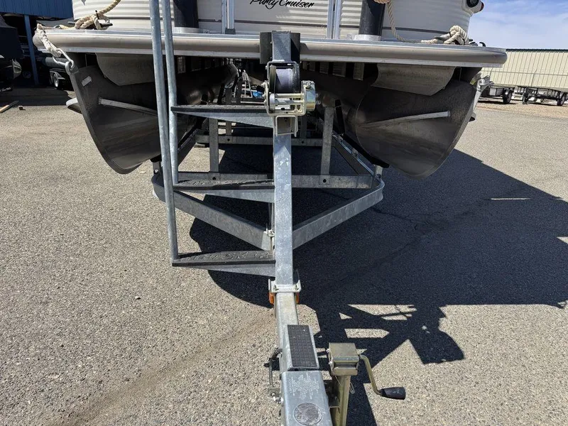 Slide: The Image of 2006 Sun Tracker Party Cruiser 32 on trailer, front view, parked on asphalt. - 39
