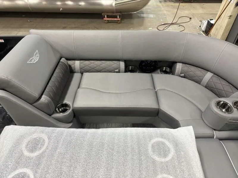 Slide: The Image of 2025 Bennington 22 LSRSE pontoon boat with cover in a warehouse setting. - 9