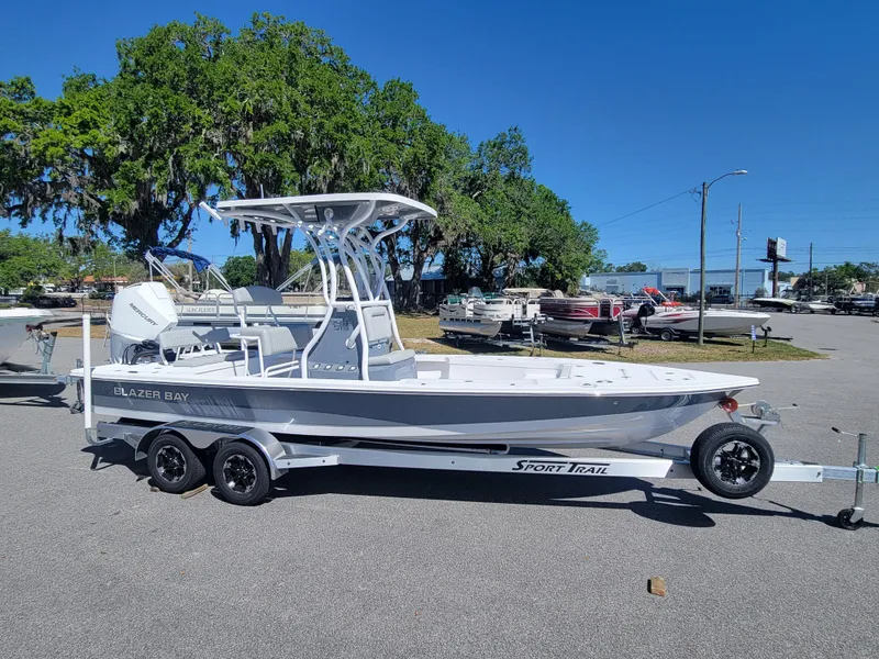 The Image of 2025 Blazer Bay 2420 GTS Deluxe boat on trailer, parked outdoors under clear blue sky. - 1