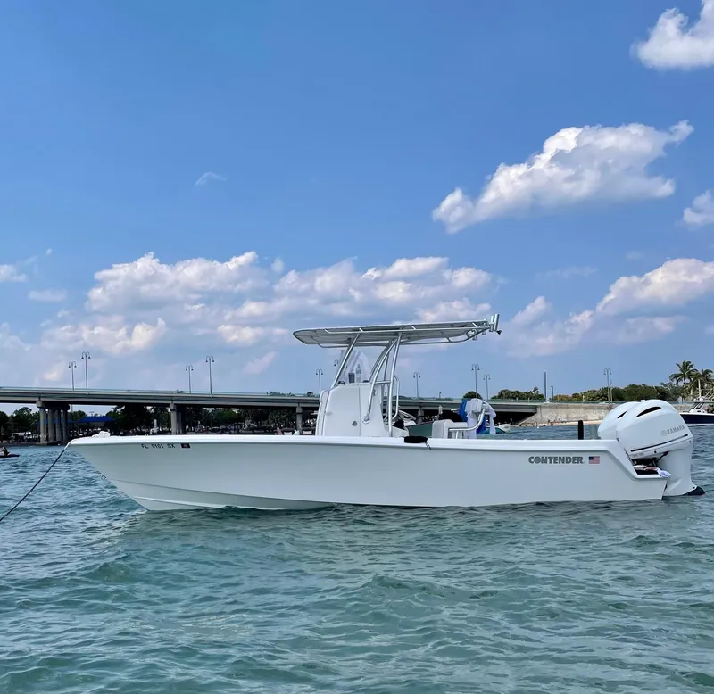 Slide: The Image of 2021 Contender Tournament boat on water under blue sky and clouds. - 0