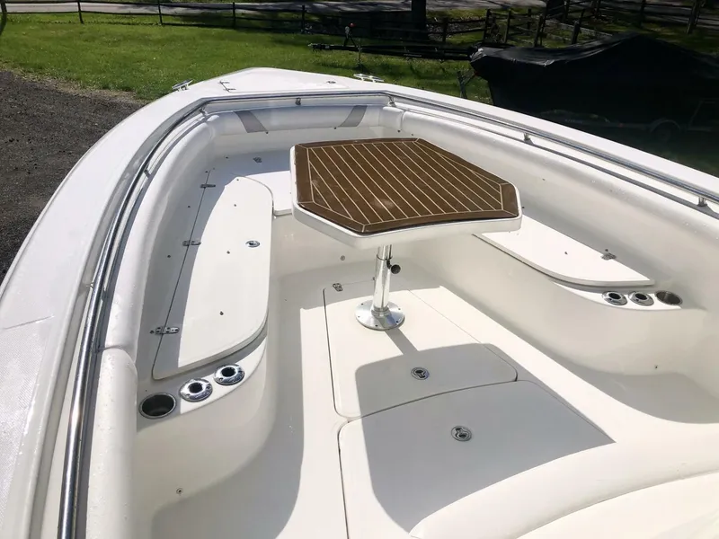 Slide: The Image of 2016 Boston Whaler OUTRAGE boat interior with seating and wooden table. - 20