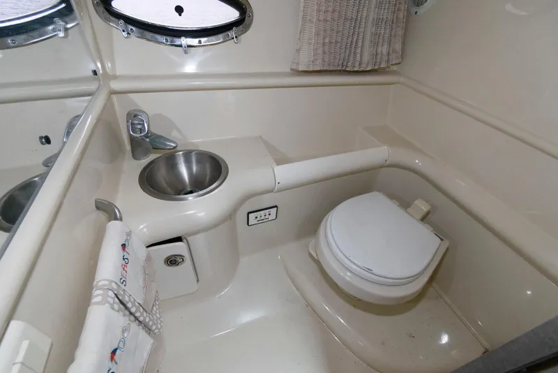 Slide: The Image of 2007 Formula 330 Sun Sport boat bathroom with sink, toilet, and porthole window. - 13