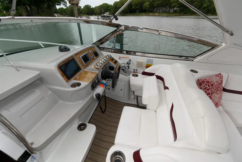 Slide: The Image of 2007 Formula 330 Sun Sport boat interior with white seating and control panel on a calm river. - 5