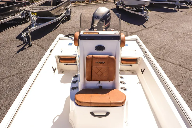 Slide: The Image of 2025 Avid 20 ROGUE CC boat interior with brown seating and modern design. - 13