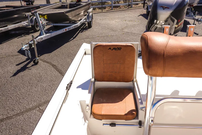 Slide: The Image of 2025 Avid 20 ROGUE CC boat seat with brown leather upholstery and nearby trailer. - 18