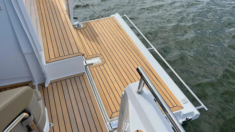 Slide: The Image of Teak deck of 2025 Nimbus Weekender 11 #49 boat on water. - 13