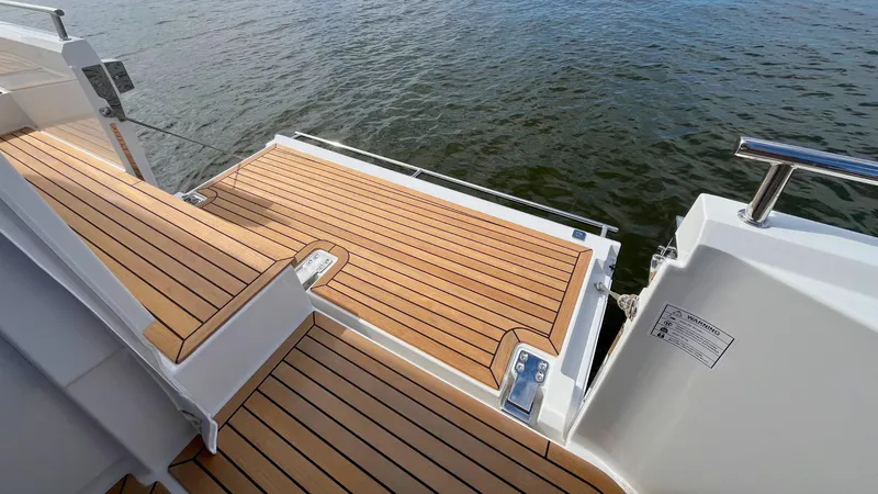 Slide: The Image of Teak deck of 2025 Nimbus Weekender 11 #49, overlooking calm water. - 17