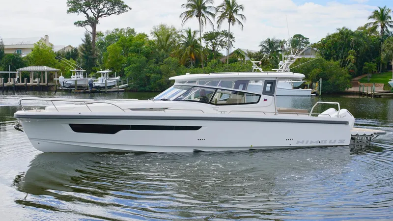 Slide: The Image of 2025 Nimbus Weekender 11 #49 boat cruising on a serene waterway with lush greenery. - 35