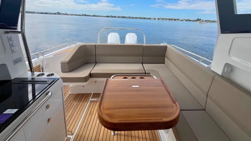 Slide: The Image of Luxurious 2025 Nimbus Weekender 11 #49 boat interior with seating and wooden table, overlooking serene waters. - 5