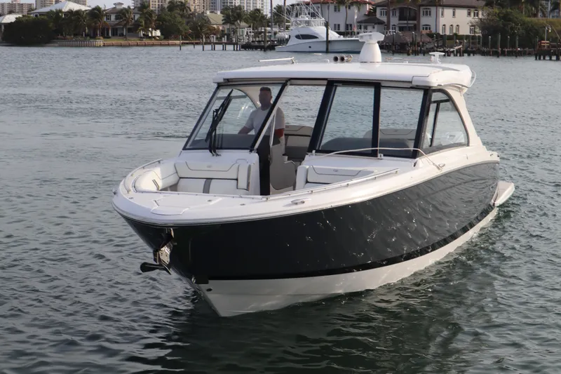 Slide: The Image of 2022 Regal LX36 boat cruising on calm waters near a marina. - 5