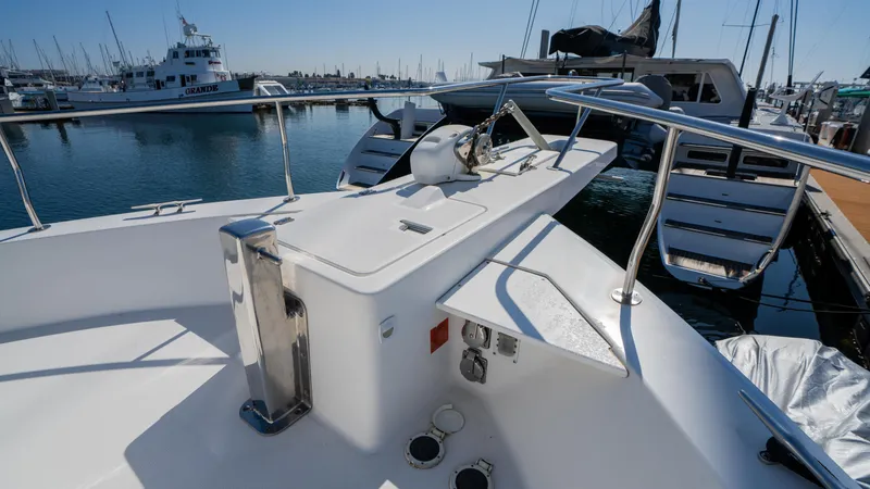 Slide: The Image of 2005 Mainship 43 Trawler Aft Cabin, docked in a marina, showcasing deck and railing. - 17