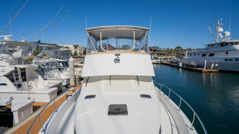 Slide: The Image of 2005 Mainship 43 Trawler Aft Cabin docked in a marina under clear blue skies. - 19