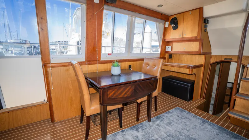 Slide: The Image of 2005 Mainship 43 Trawler Aft Cabin interior with dining area and wooden furnishings. - 21