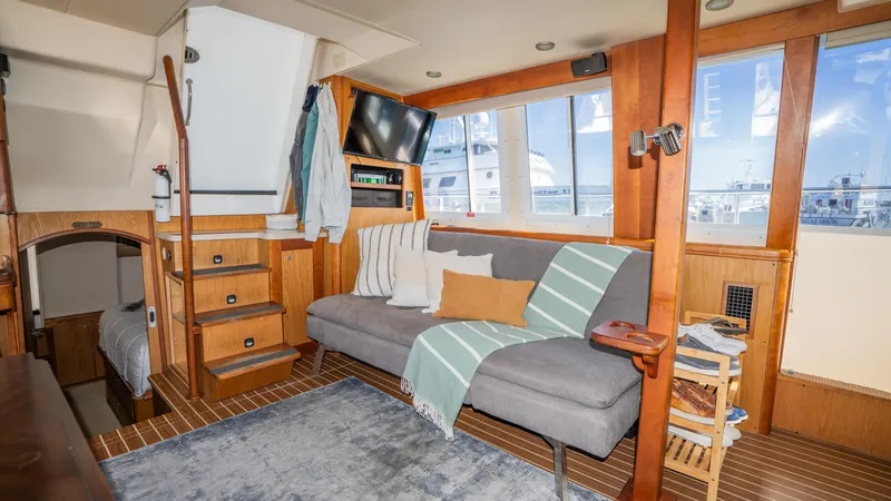 Slide: The Image of 2005 Mainship 43 Trawler Aft Cabin interior with cozy seating and nautical decor. - 22
