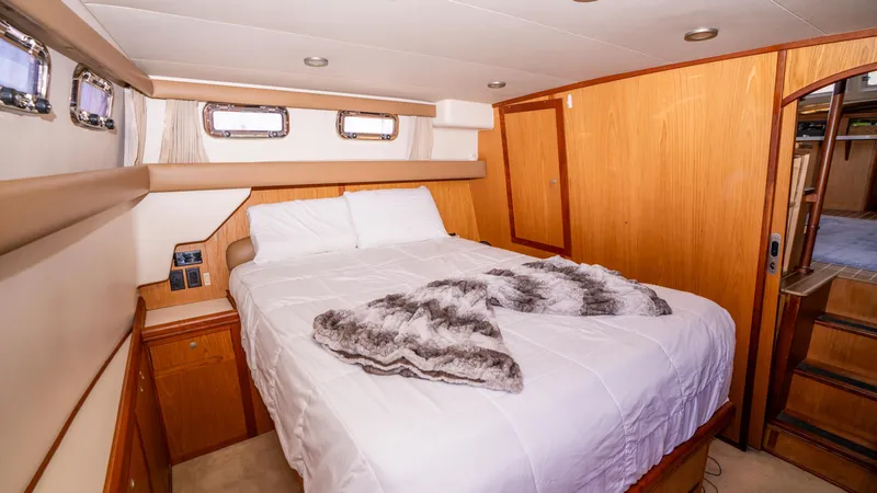 Slide: The Image of Aft cabin bedroom in 2005 Mainship 43 Trawler, featuring cozy bed and wooden interior. - 23