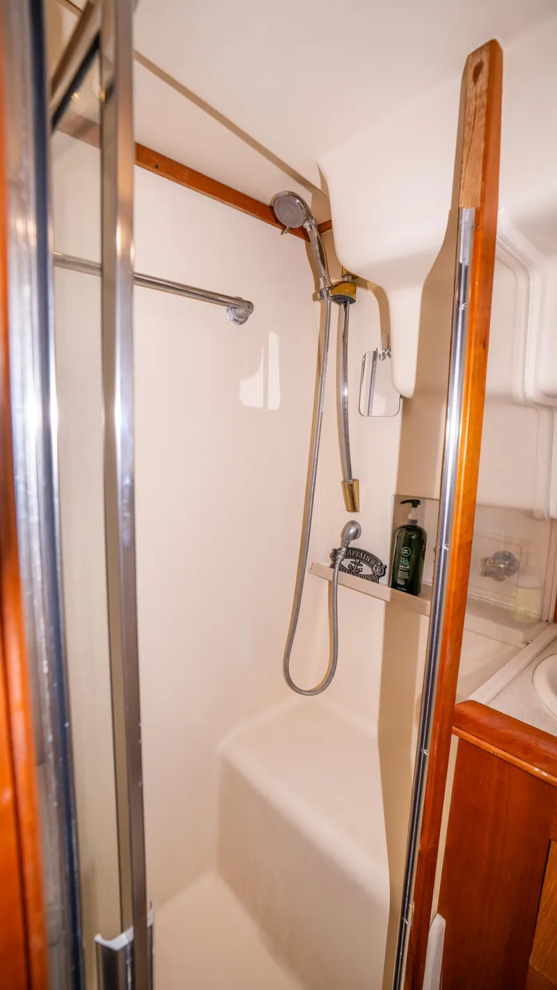 Slide: The Image of 2005 Mainship 43 Trawler Aft Cabin shower with glass door and handheld showerhead. - 27