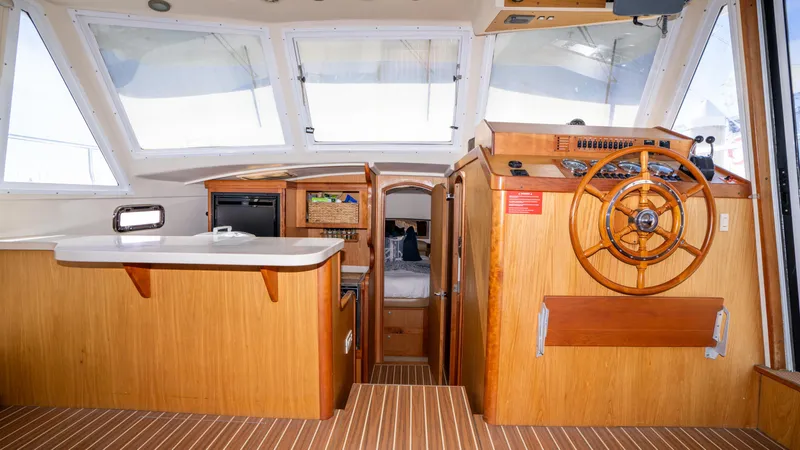 Slide: The Image of 2005 Mainship 43 Trawler Aft Cabin interior with wooden helm and spacious cabin layout. - 29
