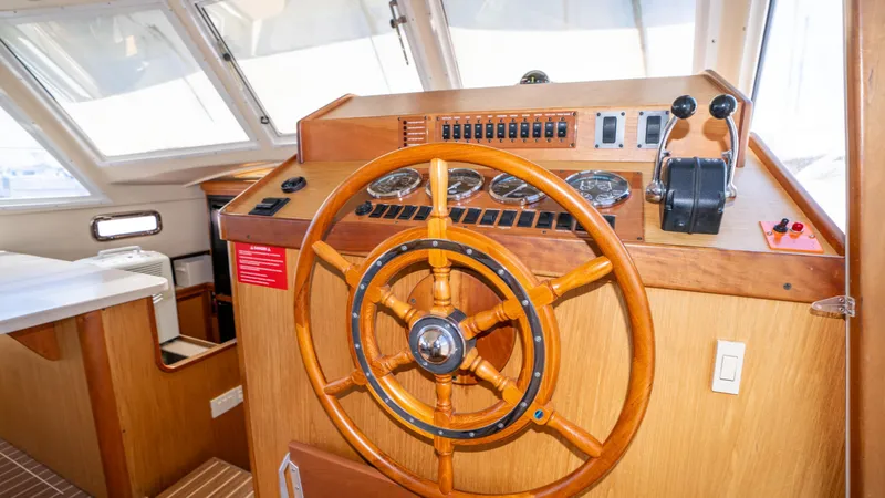 Slide: The Image of 2005 Mainship 43 Trawler Aft Cabin helm with wooden steering wheel and control panel. - 31