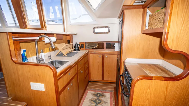 Slide: The Image of 2005 Mainship 43 Trawler Aft Cabin kitchen with wood cabinetry and modern appliances. - 35