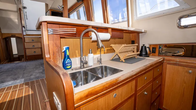 Slide: The Image of 2005 Mainship 43 Trawler Aft Cabin kitchen with wooden cabinetry and stainless steel sink. - 36