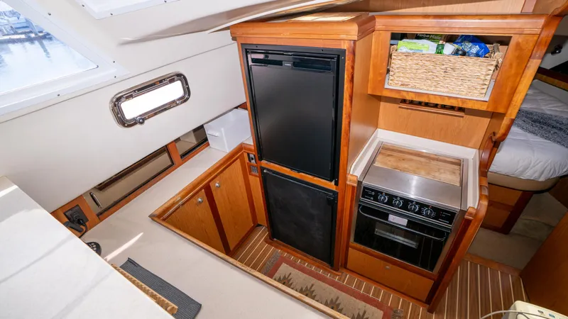 Slide: The Image of 2005 Mainship 43 Trawler Aft Cabin kitchen with fridge, stove, and storage. - 37