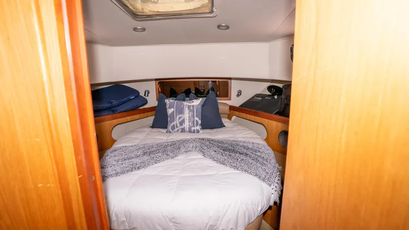 Slide: The Image of 2005 Mainship 43 Trawler Aft Cabin bedroom with cozy bedding and wooden accents. - 38