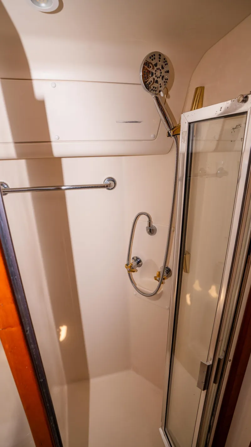 Slide: The Image of Shower area in 2005 Mainship 43 Trawler Aft Cabin, featuring glass door and chrome fixtures. - 42