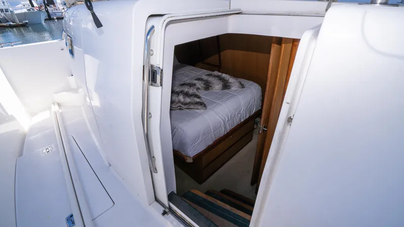 Slide: The Image of 2005 Mainship 43 Trawler Aft Cabin interior with cozy bed and wooden accents. - 47