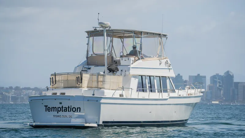 Slide: The Image of 2005 Mainship 43 Trawler Aft Cabin cruising on water with city skyline in background. - 5