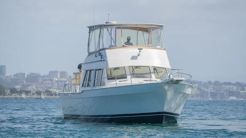 Slide: The Image of 2005 Mainship 43 Trawler Aft Cabin cruising on calm waters near city skyline. - 9
