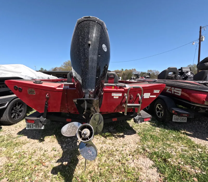Slide: The Image of 2023 Ranger RT188 boat with outboard motor, parked on grass under clear blue sky. - 6