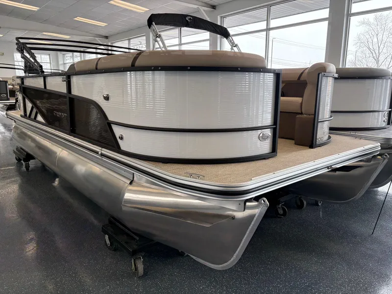 The Image of 2025 Crest 20L pontoon boat in showroom, featuring sleek design and comfortable seating. - 0